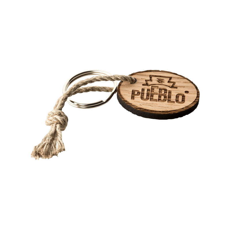 Ovaler PUEBLO Schlüsselanhänger aus Holz, PUEBLO Schriftzug und Logo, befestigt an einem Metallring mit einem Knoten aus Naturfaserband.